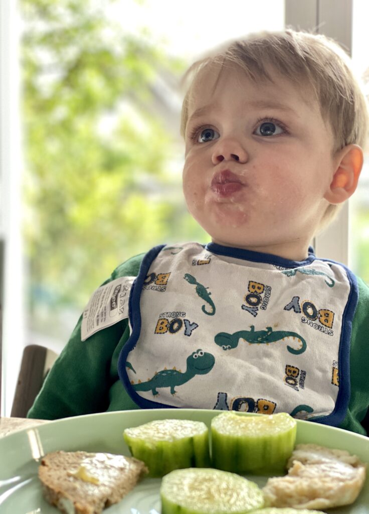 a child eating a plate of cucumbers